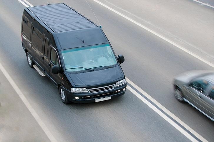 czarny minibus towarowy jadący autostradą